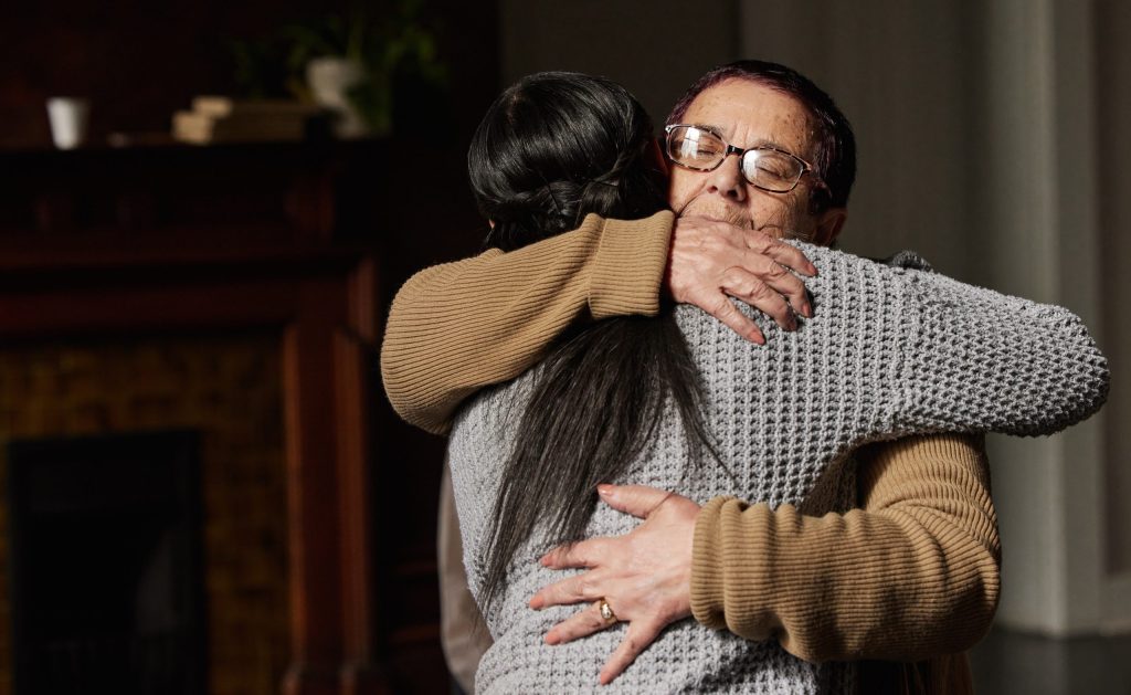 Two women hugging and supporting each other's mental health